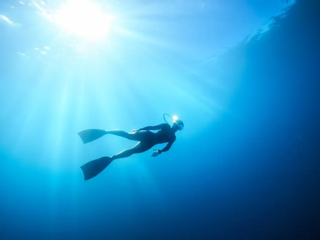 Buceo en apnea y freediving: Imagen de un apneísta descendiendo con gracia en aguas cristalinas, rodeado de vida marina vibrante